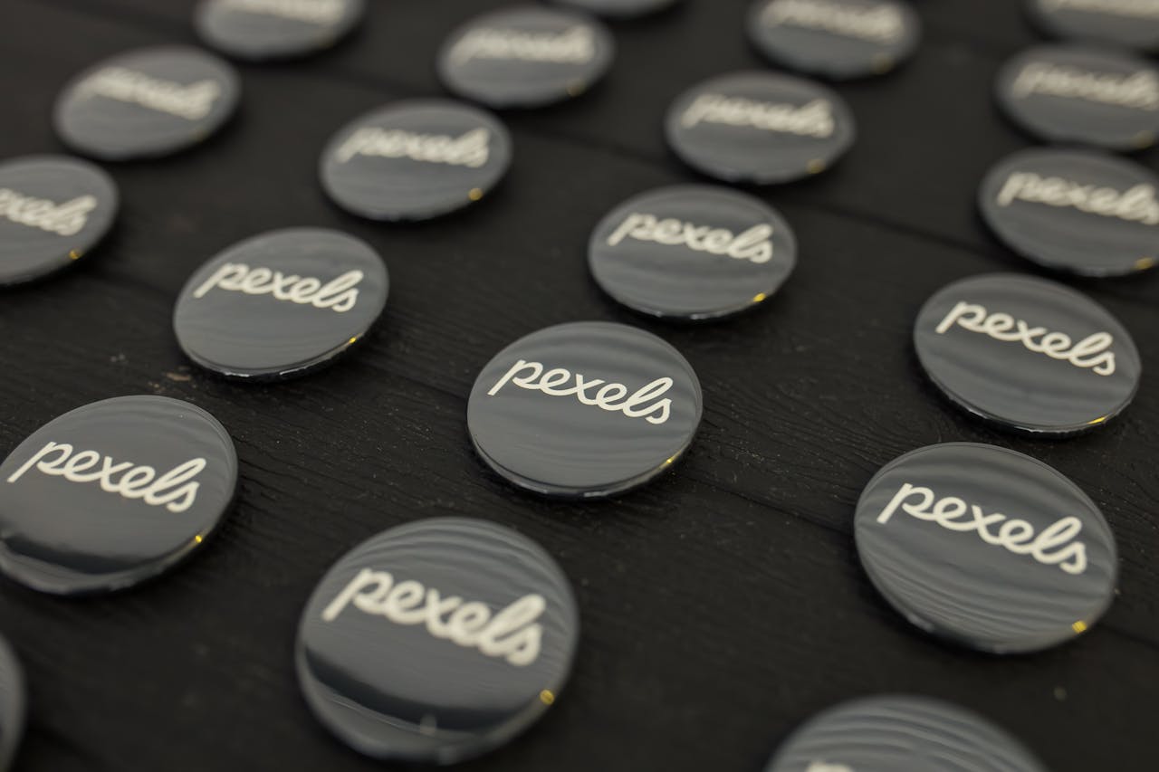 A close-up view of multiple Pexels logo buttons arranged neatly on a dark surface.